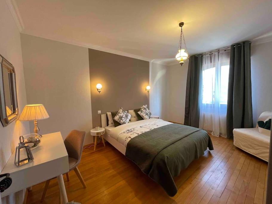 a bedroom with a bed and a table and a desk at EVASION gîtes et spa in Saint-Léonard