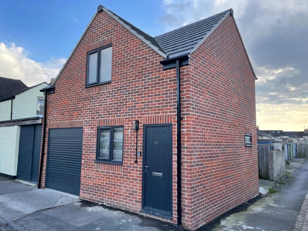 um edifício de tijolos vermelhos com uma porta preta em Welcome properties - Self Check-In whole apartment em Swindon