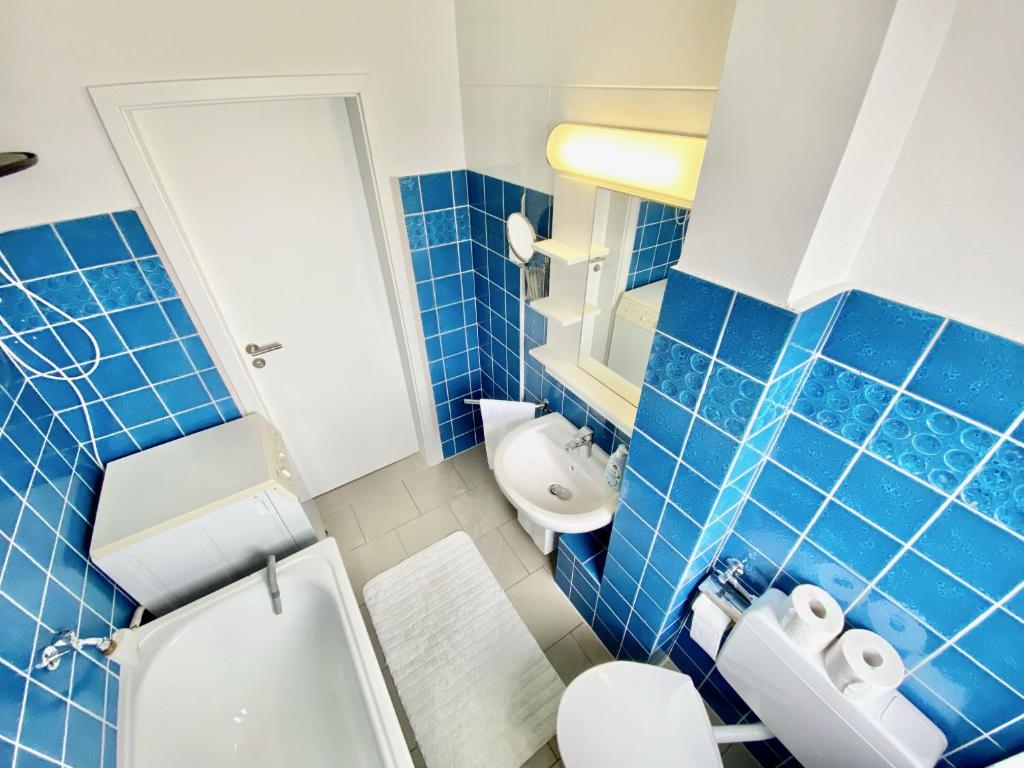 bagno piastrellato blu con servizi igienici e lavandino di Zentral gelegene 2 Zi. Wohnung nähe Innenstadt/HBF a Wolfsburg