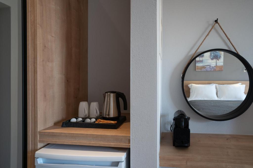 a mirror on a shelf in a room with a bed at Sarah Luxury Rooms in Syvota