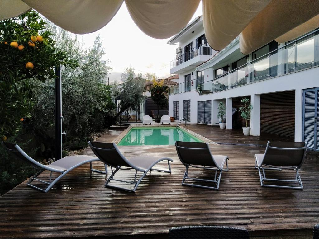 eine Terrasse mit Stühlen und einem Pool in der Unterkunft Vilaportuguesa in Vila Velha de Ródão