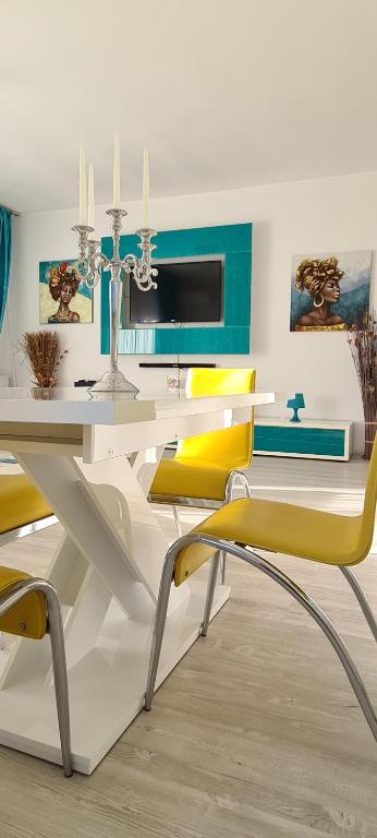 ママイア・ノルドにあるApartament Blue Seaのダイニングルーム(白いテーブル、黄色の椅子付)