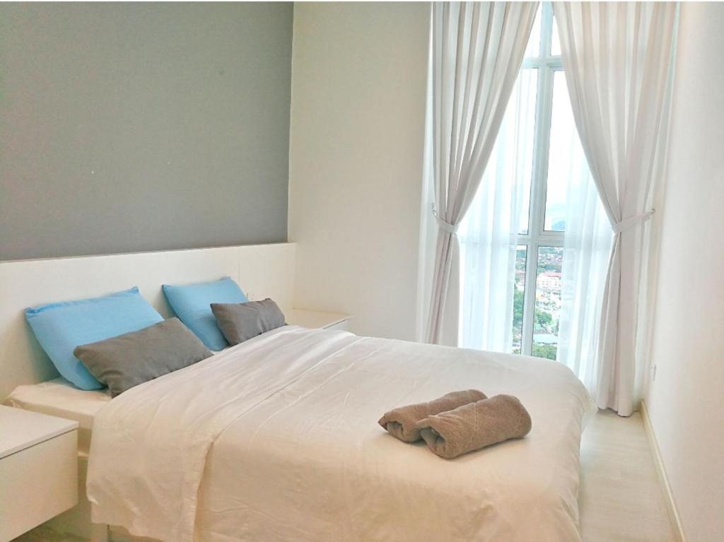 JelutongにあるDeluxe & Feel Like a Home 2, 3-6pax, Netflix, Georgetownのタオルが敷かれた白いベッドのある寝室
