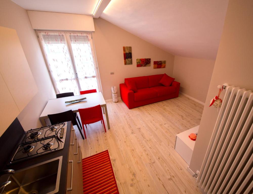 - un salon avec un canapé rouge et une table dans l'établissement Appartements Chez Maghy, à Aoste