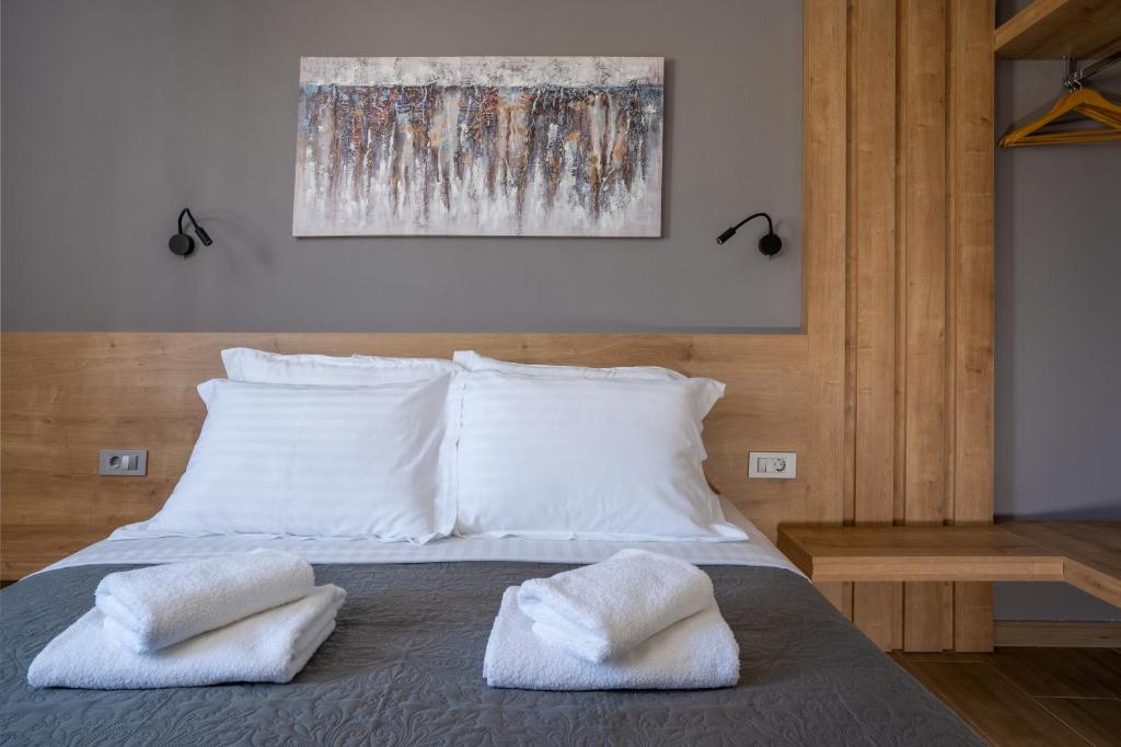 a bedroom with a bed with two towels on it at Sarah Luxury Rooms in Syvota