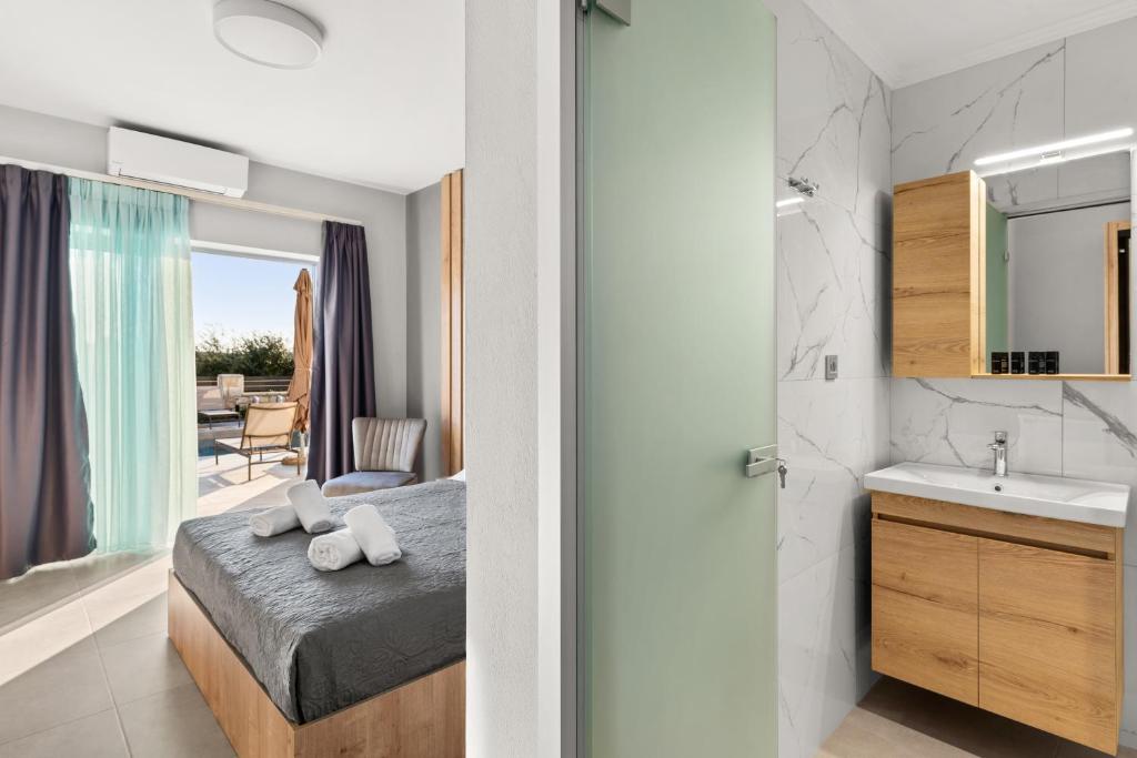 a bedroom with a bed and a bathroom with a sink at Sarah Luxury Rooms in Syvota