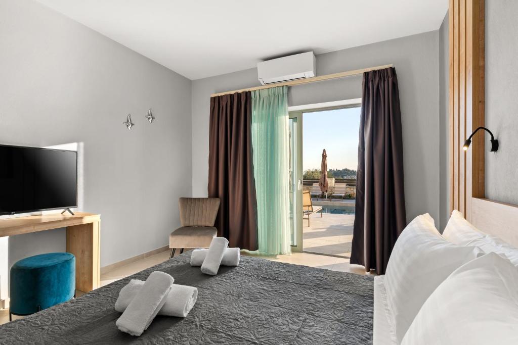 a hotel room with a bed and a tv and a bedroom at Sarah Luxury Rooms in Syvota