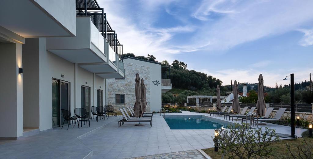 a villa with a swimming pool and a patio at Sarah Luxury Rooms in Syvota