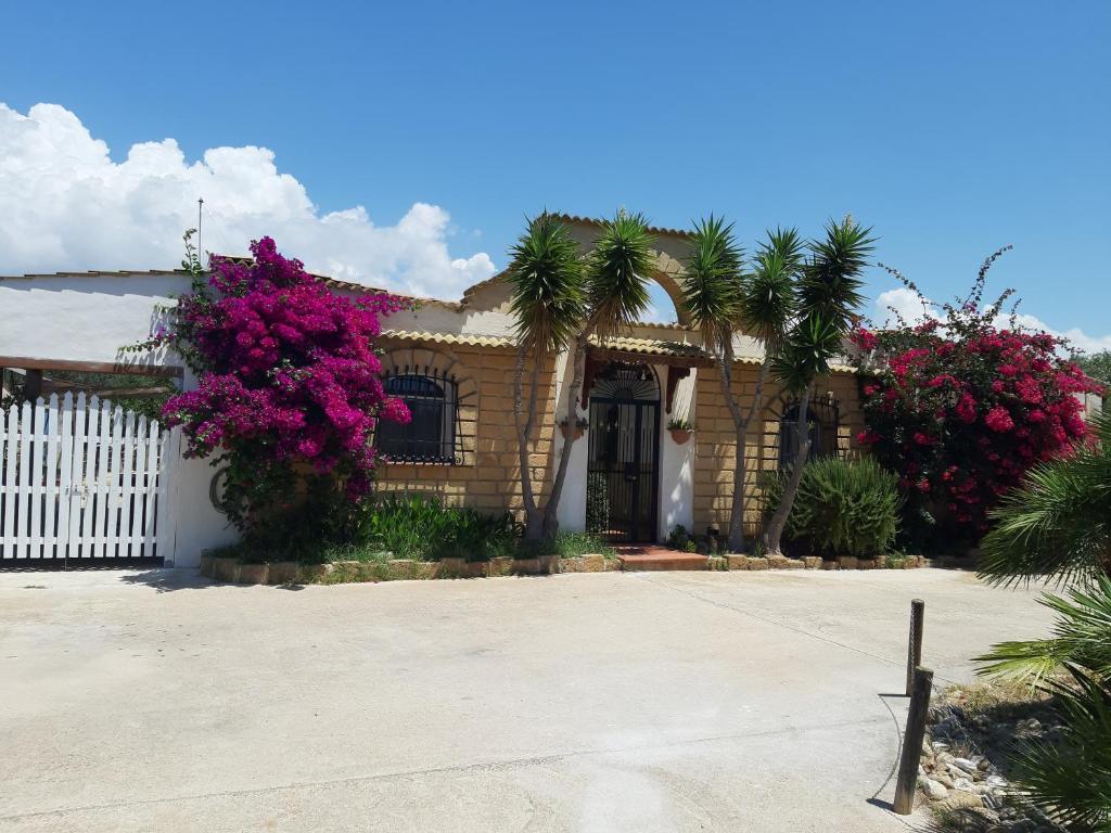 a house with pink flowers and a white fence at Casa vacanze Villa Liù in Sciacca