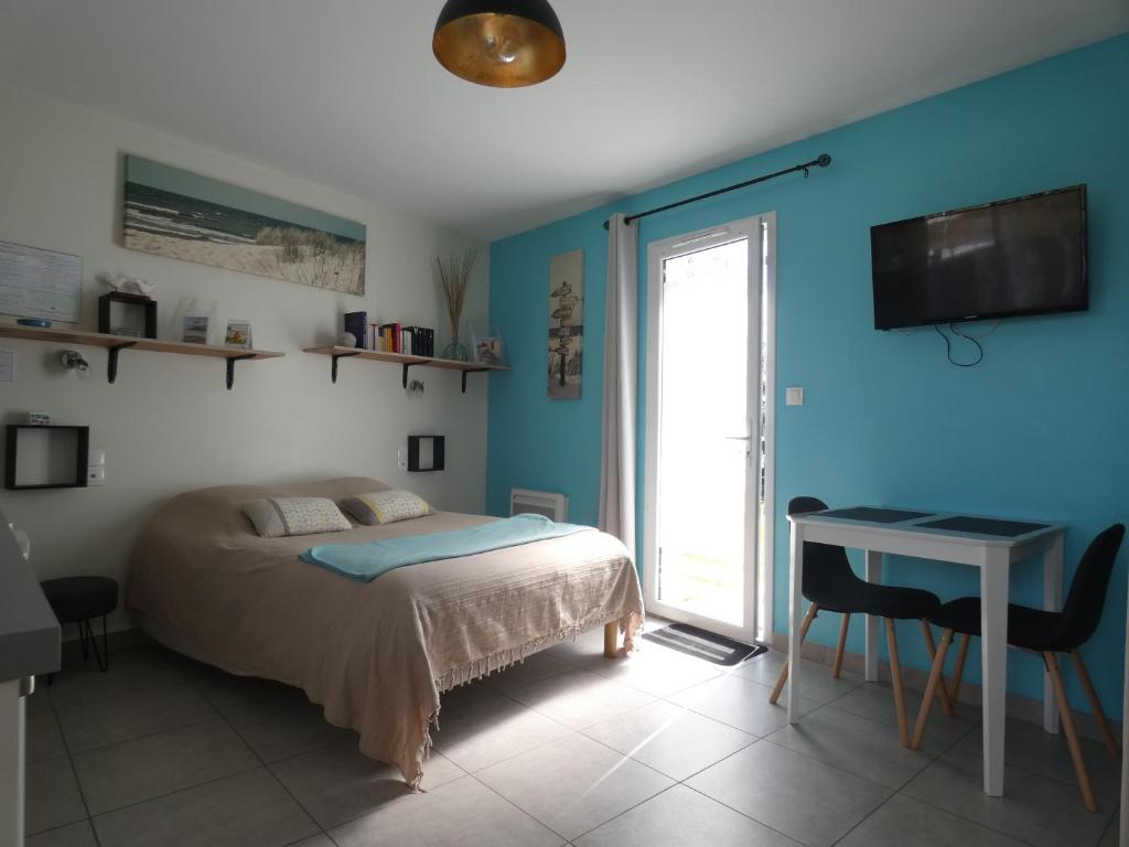 ein Schlafzimmer mit Bett, Schreibtisch und Fenster in der Unterkunft Grain de Sable et son Jacuzzi in Talmont