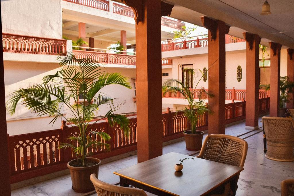 a balcony with a table and chairs and plants at Suryaa Villa - A Boutique Heritage Hotel in Jaipur