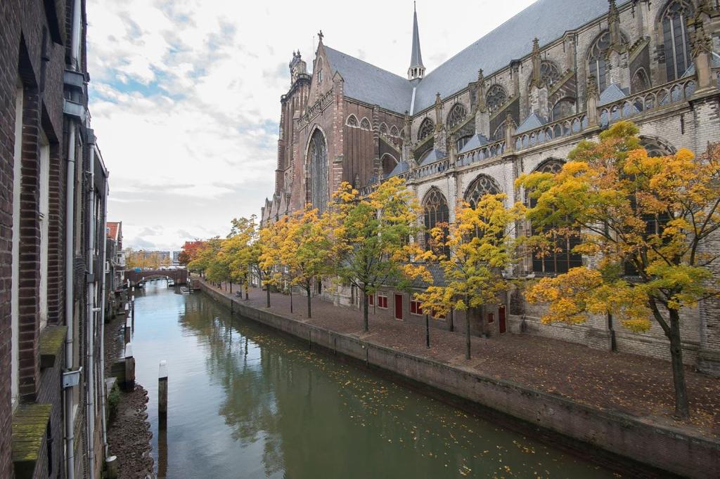 un río frente a un edificio y una iglesia en Voorstraat-Havenzicht 2de en Dordrecht
