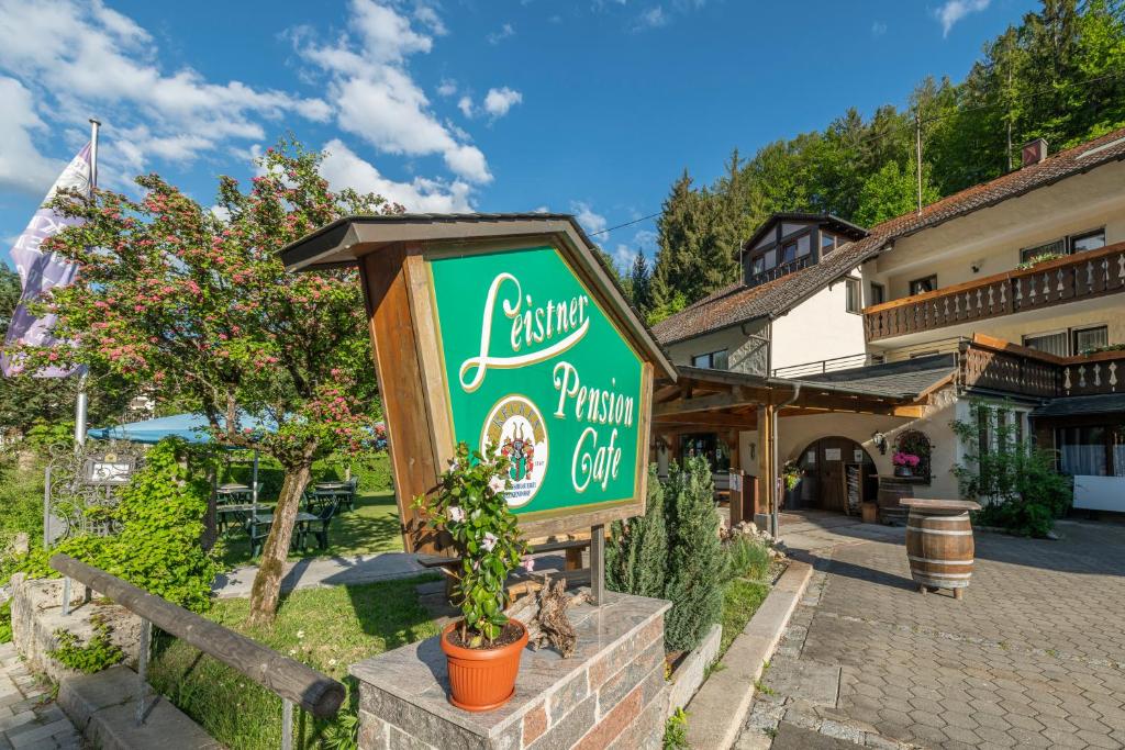 un cartel para una pizzería frente a un edificio en Café Pension Leistner, en Obertrubach