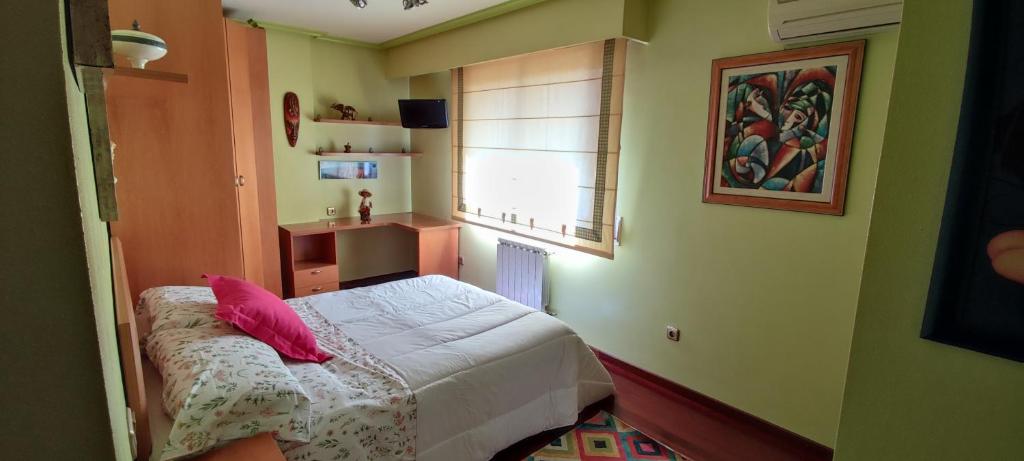 a small bedroom with a bed and a window at Piso Estación Termal GARAJE Y AIRE ACONDICIONADO in Ourense