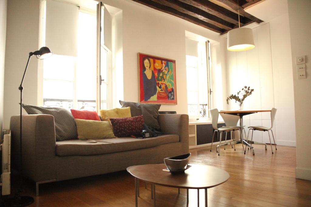 sala de estar con sofá y mesa en Sèvres-Raspail Paris 6 apartment, en París
