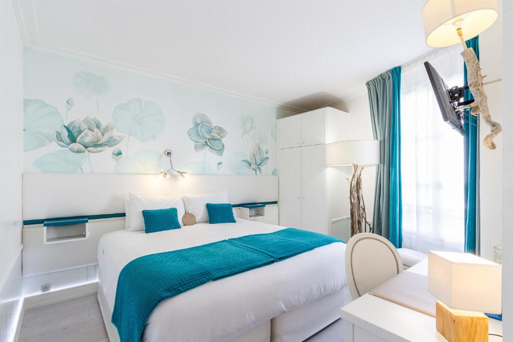 a bedroom with a large bed with blue accents at Hôtel Saint Albert in Sarlat-la-Canéda