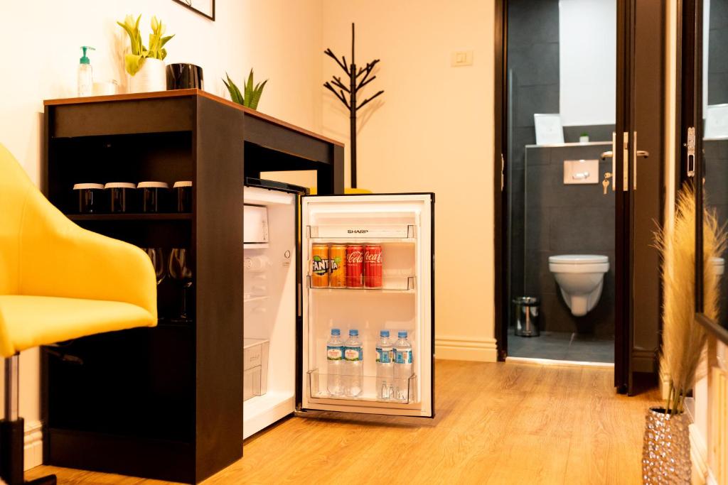 un frigorifero aperto con bevande all'interno di una stanza di Corvin Guesthouse a Hunedoara