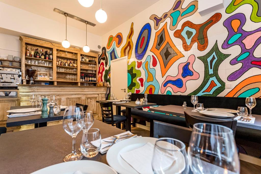 een restaurant met tafels en stoelen en een kleurrijke muur bij B&B Gracht 62 in Maastricht