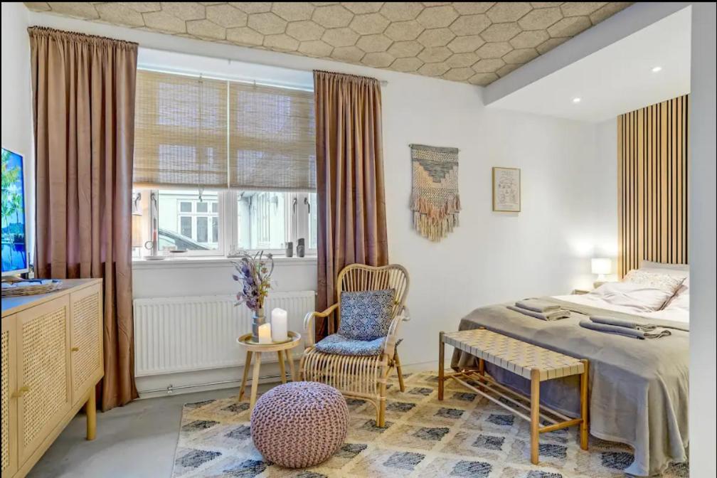 een slaapkamer met een bed, een stoel en een raam bij Boheme Retreat in Aalborg