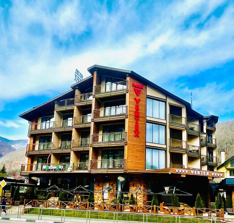 a large building with tables and chairs in front of it at VERTEX SPA hotel in Estosadok