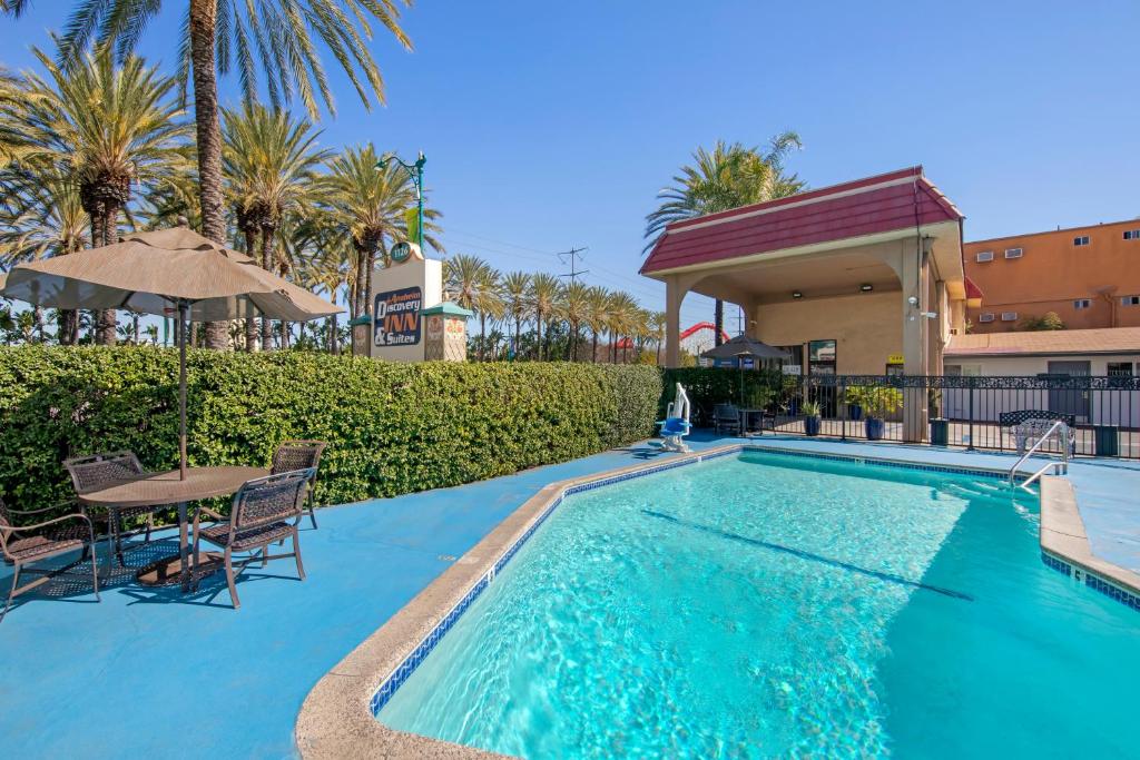a swimming pool with a table and chairs next to a building at Anaheim Discovery Inn and Suites in Anaheim