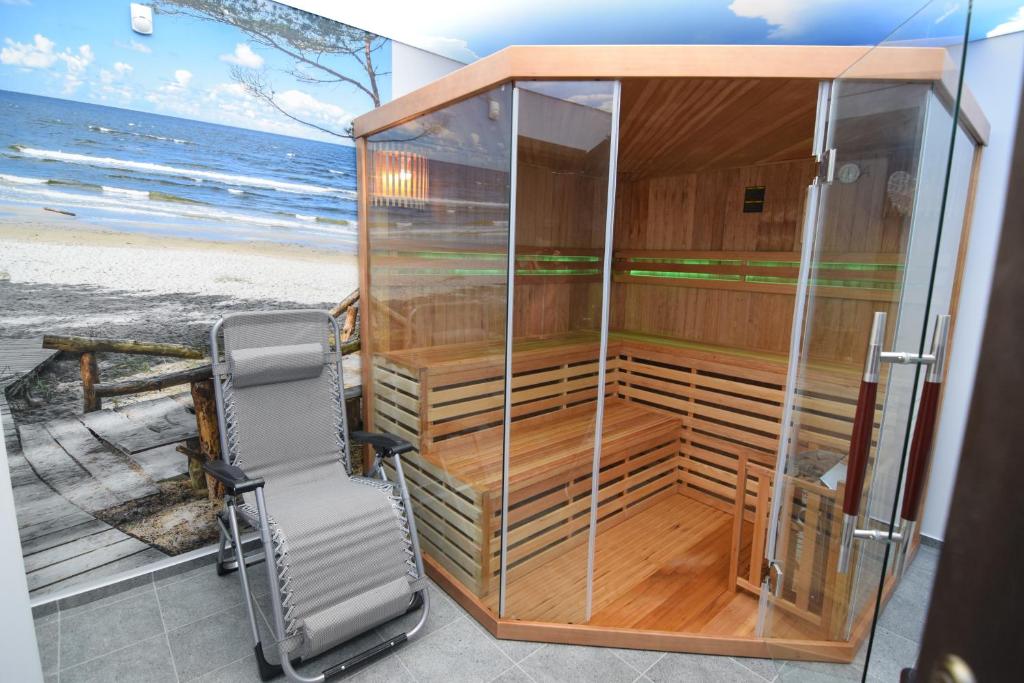 a glass booth with a chair in front of the beach at Willa Parys in Władysławowo