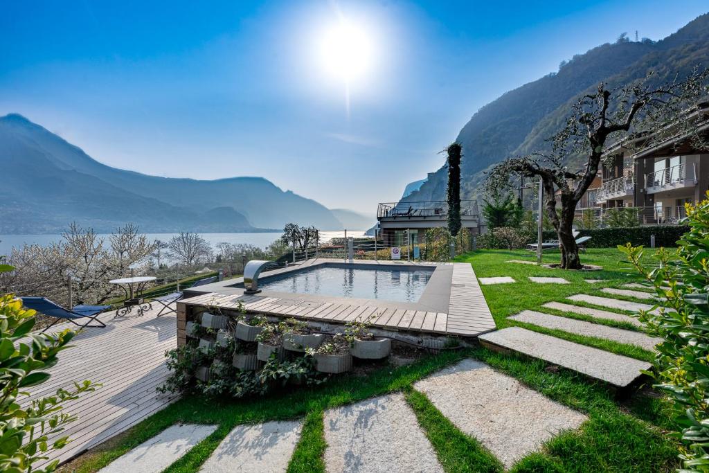 uma casa com piscina e montanhas ao fundo em Villa Vittoria with private seasonal heated pool & shared sauna - Bellagio Village Residence em Oliveto Lario