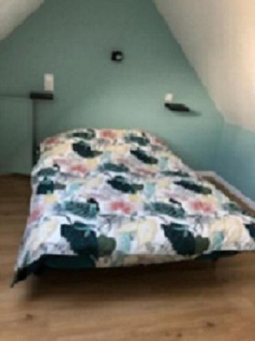 - un lit avec une couverture fleurie dans l'établissement Gîte de Vercourt, à Vercourt