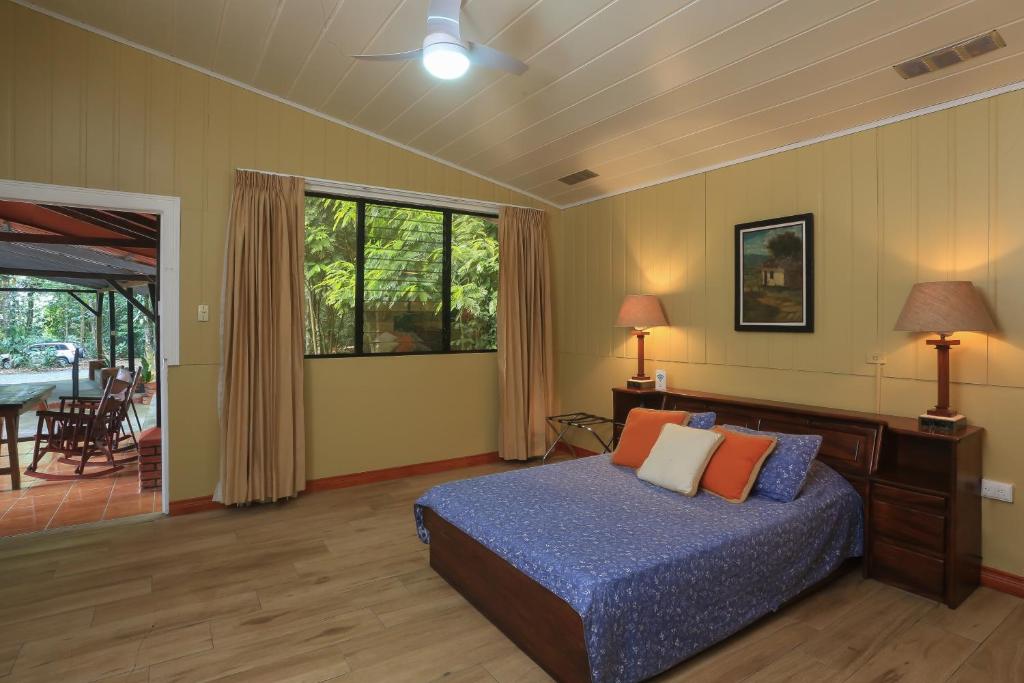 1 dormitorio con cama, mesa y patio en Horquetas River Lodge, en Sarapiquí