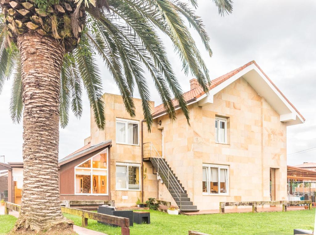 a house with a palm tree in front of it at Hotel Finca Alcamino in Mompía