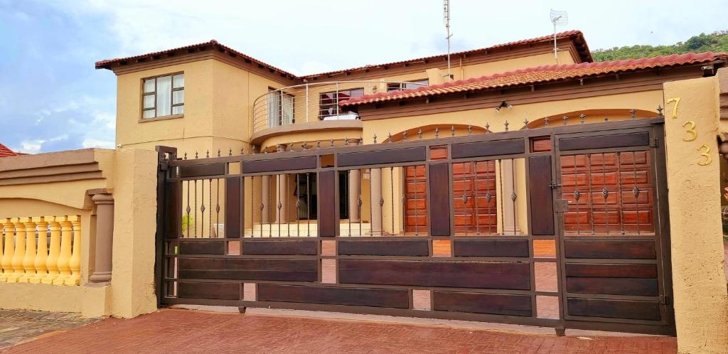una casa con una puerta de garaje de madera delante de ella en Asda guesthouse, en Mogwase
