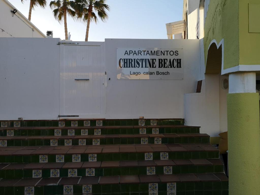 a set of stairs with a sign for aanthenos christening beach w obiekcie toni's apartament Menorca w mieście Cala'n Bosch