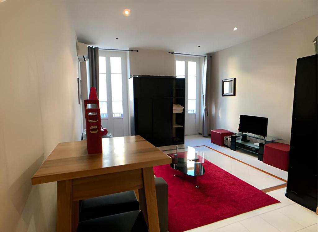 un salon avec une table et un tapis rouge dans l'établissement Studio Maccarani, à Nice