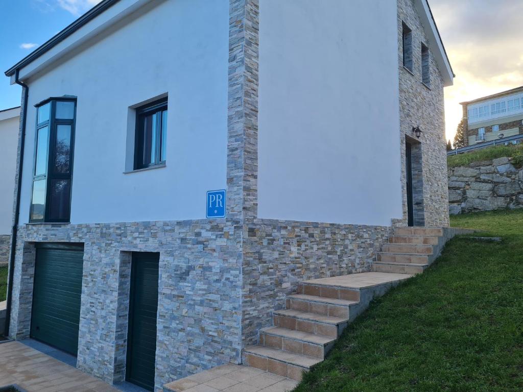 Una casa con una señal azul en el costado. en Sleeping portomarin 1 en Portomarin