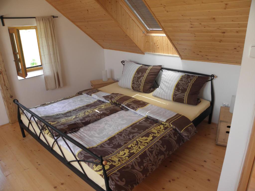 un letto in una stanza con soffitto in legno di charming house with beautiful landscape a Frýdštejn