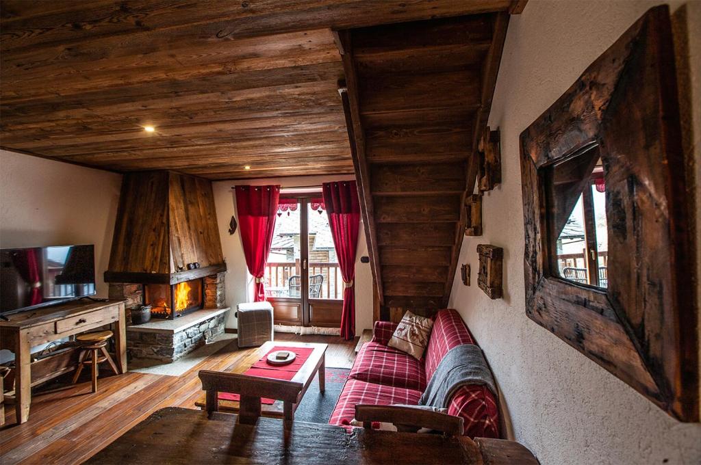 un soggiorno con divano e tavolo di L'Atelier du Temps - Chalet Les Marmottes a Cogne