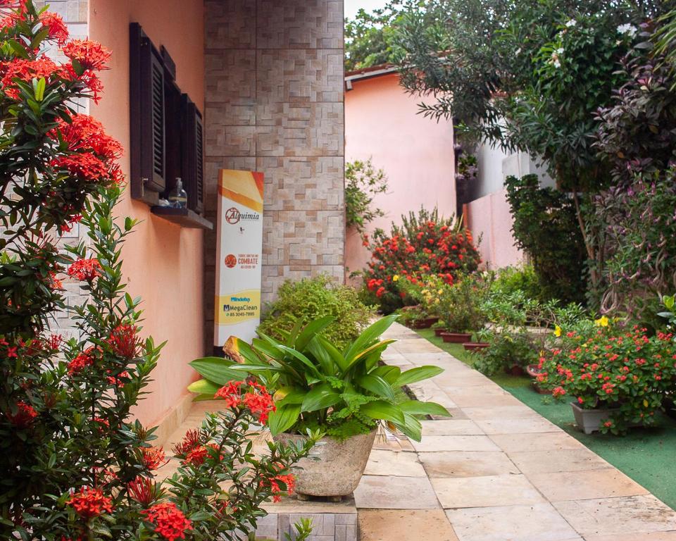 een tuin met bloemen en planten naast een gebouw bij Pousada Alquimia in Jericoacoara