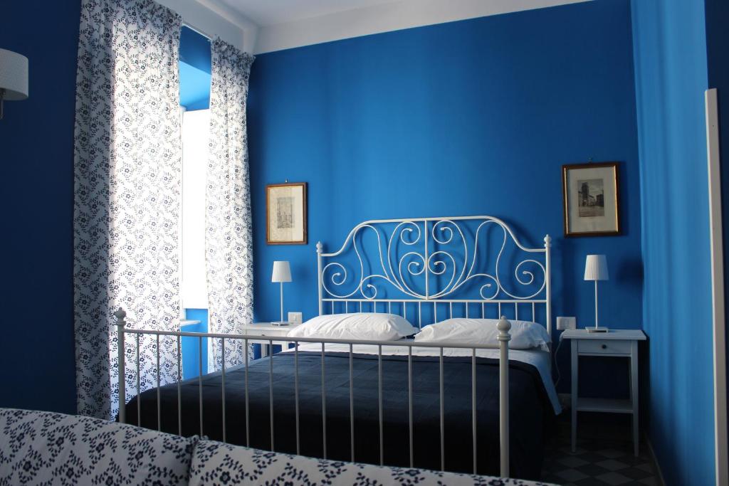 a blue bedroom with a bed and a blue wall at Le Stanze di Pietro in Rome