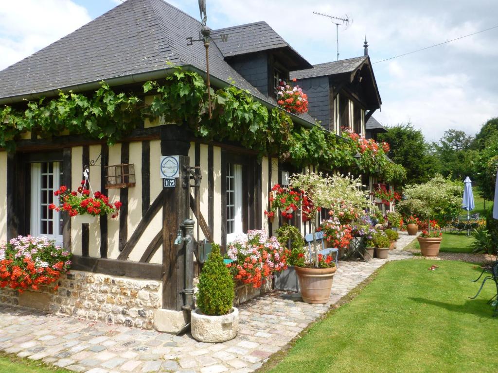 a house with flowers on the side of it at La Ferme Du Pressoir Guest House in Conteville