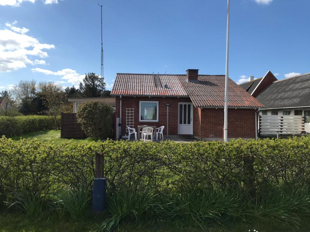 a brick house with a table and chairs in the yard at Lille Røde hus Mandø in Ribe