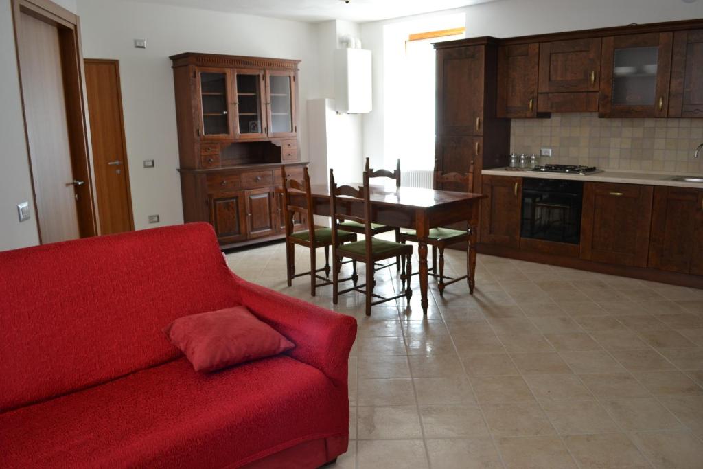 uma sala de estar com um sofá vermelho e uma mesa em Casa Ledro em Ledro