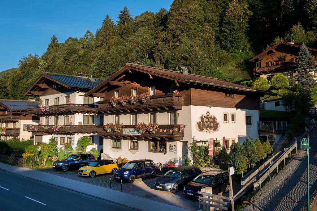 un grupo de coches estacionados frente a un edificio en Pension Schipflinger, en Saalbach Hinterglemm