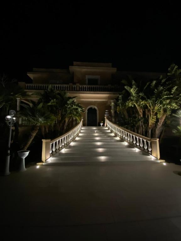 uma passagem que leva a um edifício à noite em Villa Princi em Villa San Giovanni