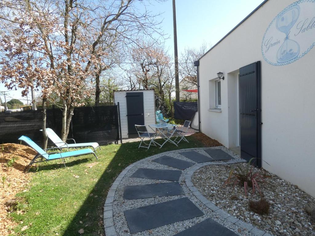 a backyard with a stone walkway next to a building at Grain de Sable et son Jacuzzi in Talmont