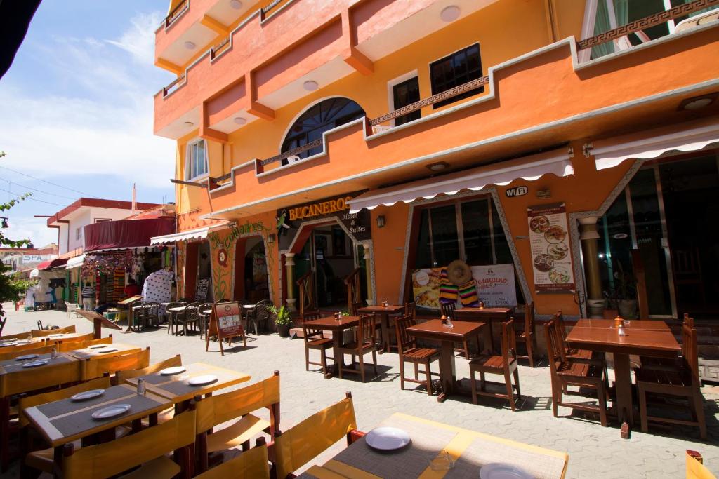 un restaurante con mesas y sillas frente a un edificio en Hotel Bucaneros Isla Mujeres, en Isla Mujeres