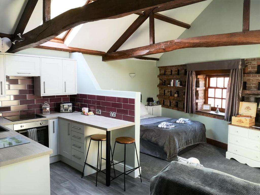 eine Küche und ein Schlafzimmer mit einem Bett in einem Zimmer in der Unterkunft The Carriage House, Studio 3A in Bilbrough