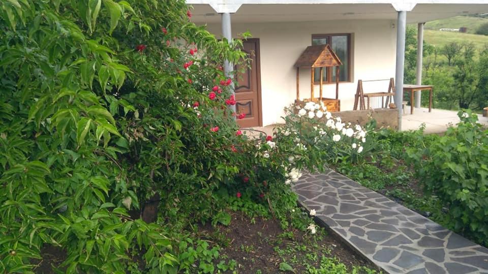 a house with a garden with flowers and a porch at AMOJ B&B and Guest house in Alaverdi