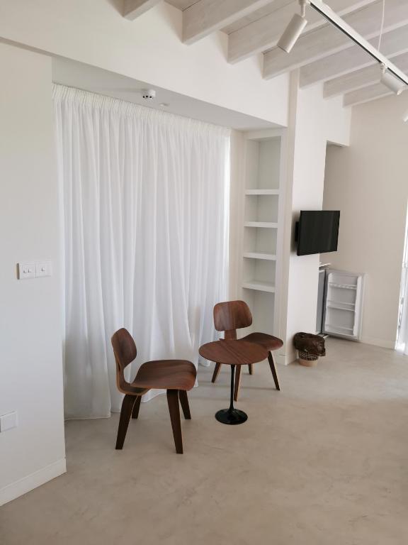 una camera con due sedie, un tavolo e una TV di Y & P LATCHI HOTEL a Lachi