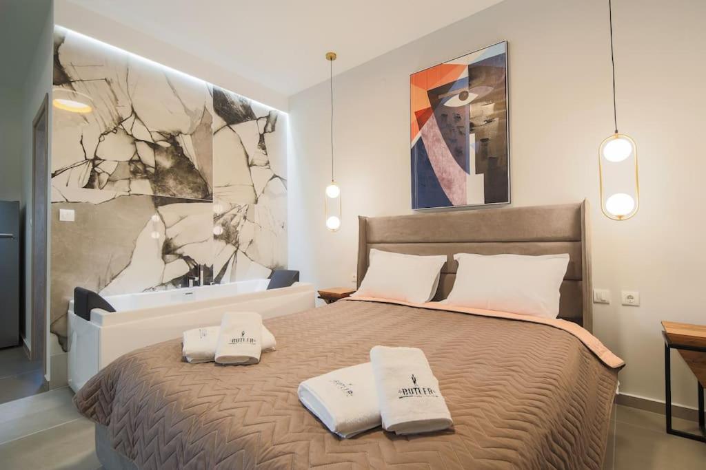 1 dormitorio con 1 cama con 2 toallas en *Oasis* Best View Jacuzzi New Central Apartment, en Volos