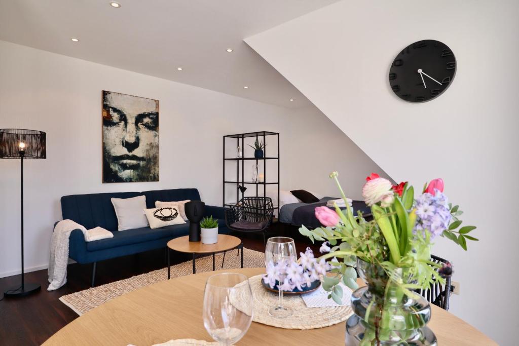 uma sala de estar com um sofá e uma mesa com flores em SUNSET APARTMENT: FREE PARKING + BALCONY + NETFLIX em Essen